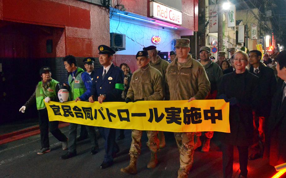 U.S. military personnel join Japanese police on a patrol through an entertainment district near Yokota Air Base, Japan, known as Bar Row on Wednesday, Nov. 20, 2019.