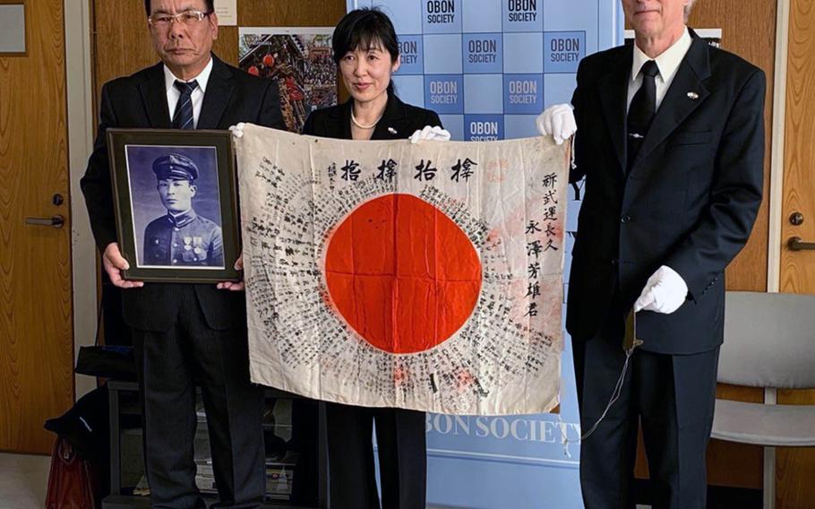 A Japanese flag carried in World War II by Yoshio Nagasawa was returned to his nephew Akitaka Nagasawa, left, in Japan by Keiko Ziak and Rex Ziak of the Obon Society on Monday. Nov. 25, 2019.