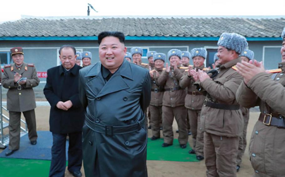 A state-run media photo purports to show North Korean leader Kim Jong Un celebrating the test fring of a large-caliber rocket system on Thursday, Nov. 28, 2019.