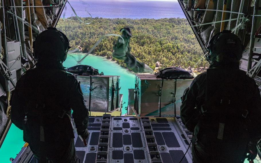 Cpl. Toni Thompson, right, and Sgt. Ethan Moran of the Royal New Zealand Air Force send supplies to a Micronesian island during Operation Christmas Drop, Wednesday, Dec. 11, 2019.