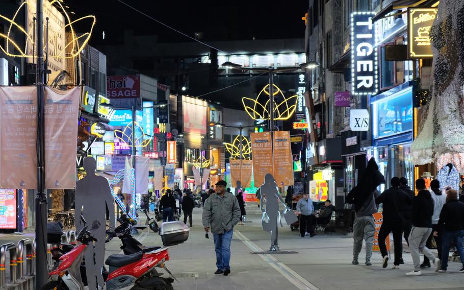 Service members and locals walk through an entertainment district just outside Osan Air Base, South Korea, on Saturday, Dec. 14, 2019.