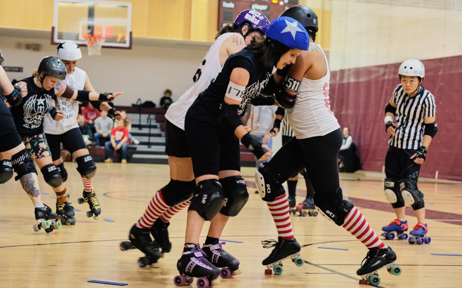 Players from the Candy Cane Crushers try to block a member of the Gingerbread Brawlers during a roller derby scrimmage at Collier Community Fitness Center on Camp Humphreys, South Korea, Saturday, Dec. 14, 2019.
