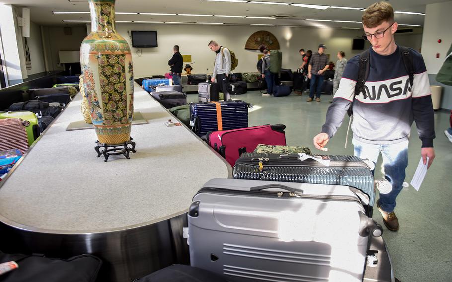 Patriot Express passengers wait for their luggage inside the passenger terminal at Yokota Air Base, Japan, in 2018.