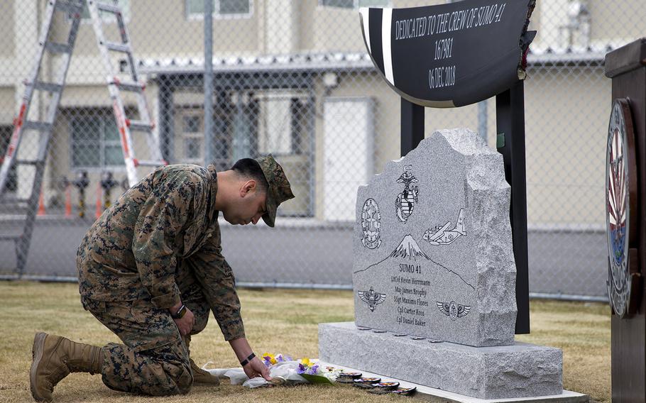 Marine Corps Sgt. Alberto Ruiz, a loadmaster with Marine Aerial Refueler Transport Squadron 152, lays flowers during the unveiling of a memorial at Marine Corps Air Station Iwakuni, Japan, Dec. 5, 2019. The memorial honors five Marine aviators killed last year in a midair collision off Japan.