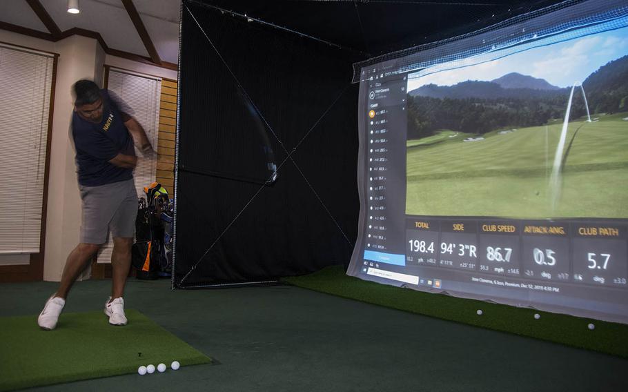 Navy Capt. Jose Cisneros practices his golf swing at a new simulator at the Par 3 Golf Course, Yokota Air Base, Tokyo, Japan, on Dec. 13, 2019.