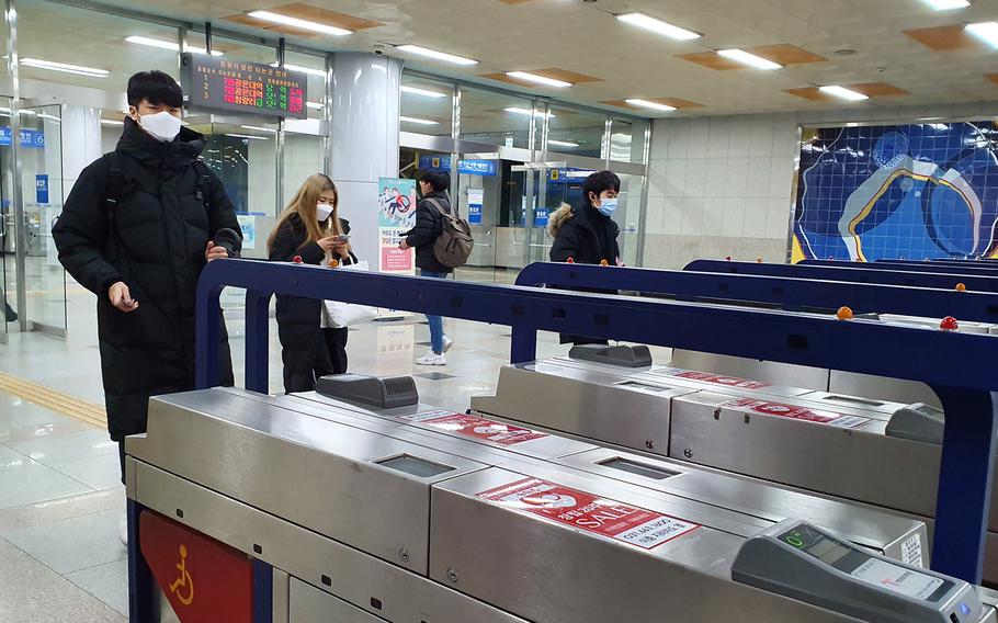 Masked commuters travel through Seojeong-ri Station, north of Pyeongtaek, South Korea, Monday, Jan. 27, 2020.