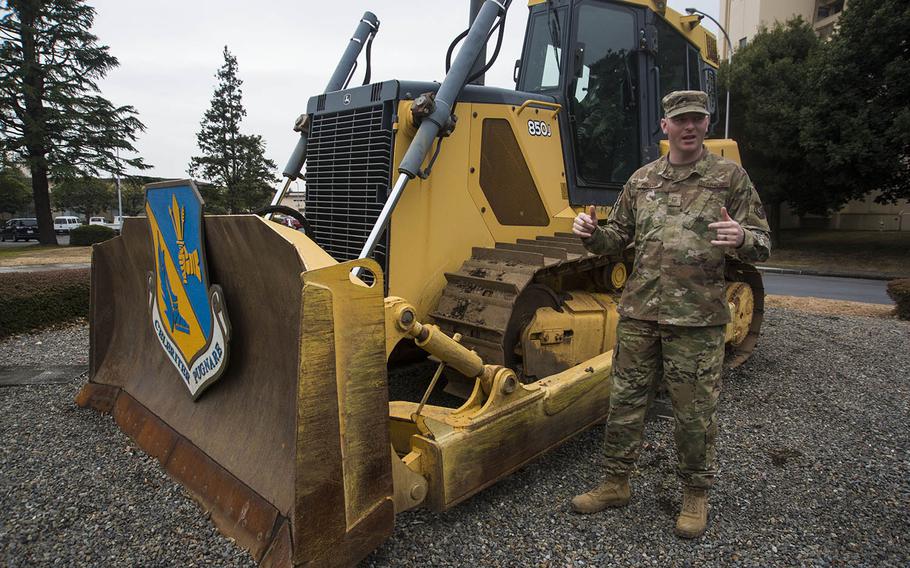 Master Sgt. Brent Fallon of the 374th Civil Engineer Squadron speaks beside a bulldozer recently displayed inside Nina Circle at Yokota Air Base, Japan, Jan. 24, 2020.