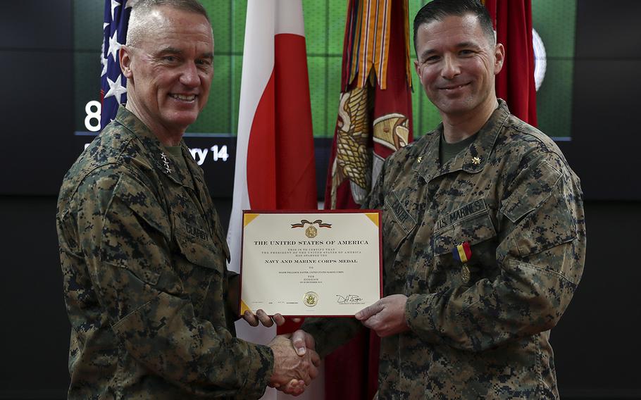 Marine Maj. William Easter, right, receives the Navy and Marine Corps Medal from III Marine Expeditionary Force commander Lt. Gen. H. Stacy Clardy at Camp Courtney, Okinawa, Feb. 14, 2020.