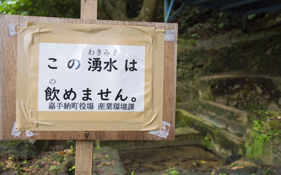 A sign posted by town officials to warn people not to drink nearby polluted spring water is pictured in Kadena, Okinawa, May 10, 2019.