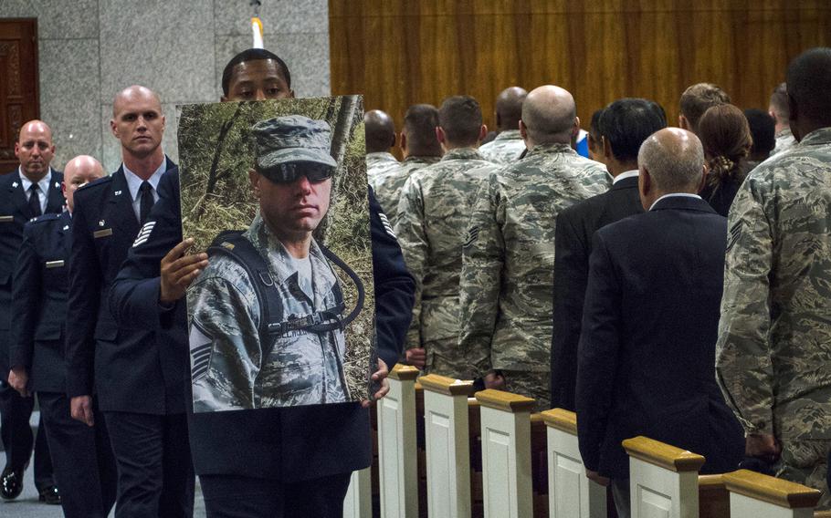 A photo of Master Sgt. Nicholas Vollweiler is carried during a memorial service at Yokota Air Base, Japan, in November 2018. He served as the security forces squadron's chief of standards and evaluation.