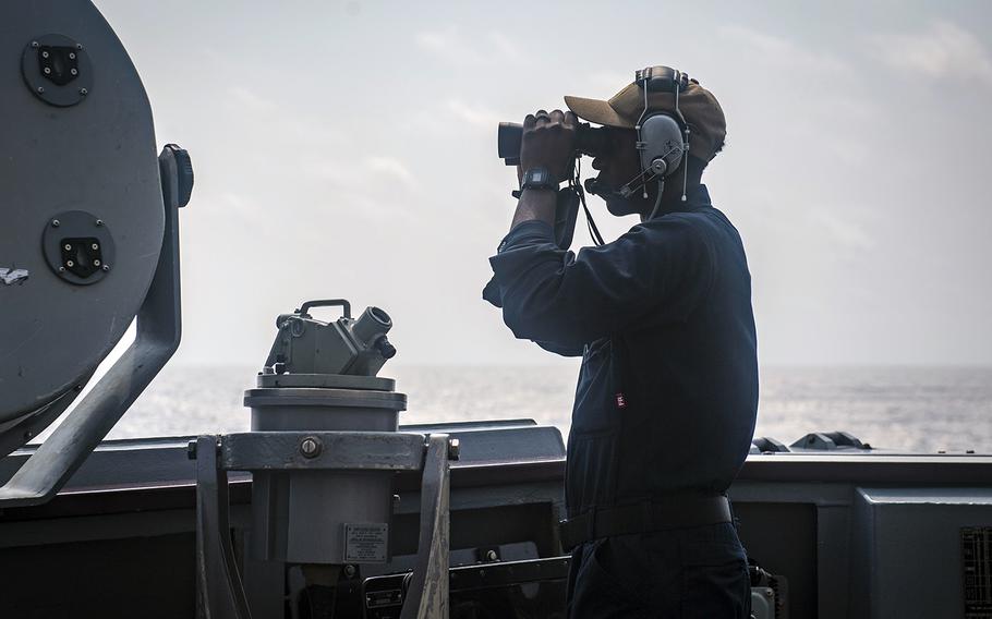 Airman Beniaah Norris scans the horizon while standing watch aboard the guided-missile destroyer USS McCampbell in the South China Sea, March 10, 2020.