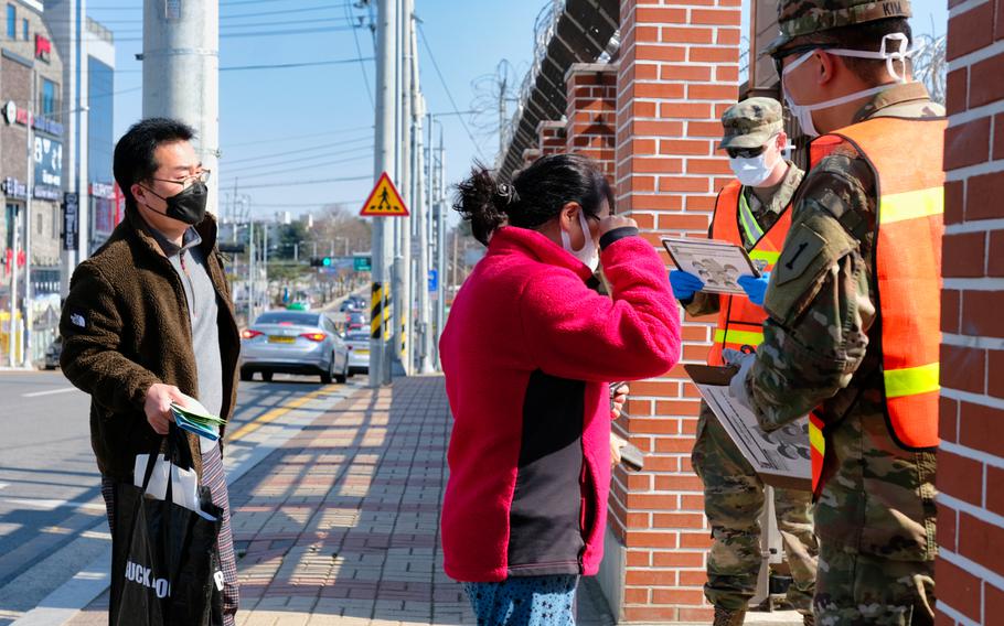 Pedestrians are screened before entering a gate at Camp Humphreys, South Korea, Monday, March 16, 2020.