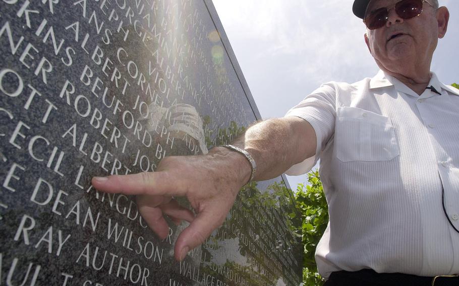Medal of Honor recipient Robert Bush traces his finger under the name of Albet Walcott at the Cornerstones of Peace Monument in Itoman, Okinawa, June 15, 2003. Walcott was a friend and comrade-in-arms who died during the Battle of Okinawa.