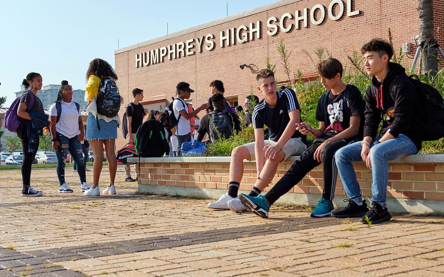 Students connect with friends outside Humphreys High School at Camp Humphreys, South Korea, Monday, Aug. 26, 2019.