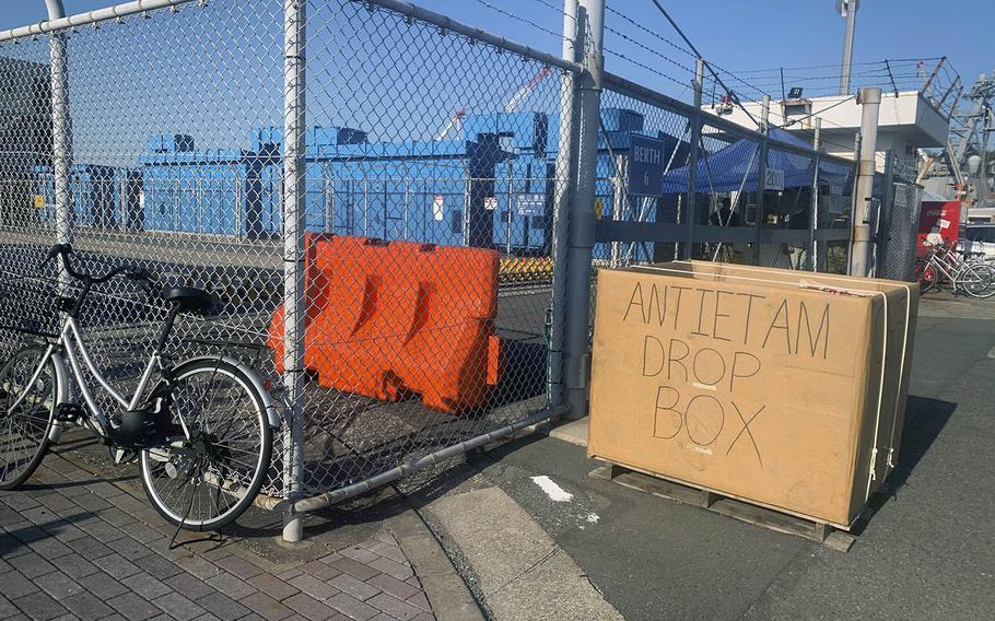 A drop box for exchange items stands outside the gate leading to the USS Antietam at Yokosuka Naval Base, Japan, March 26, 2020.