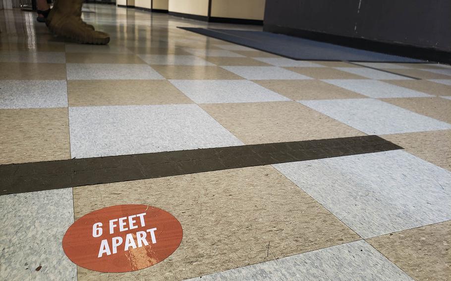 A floor decal inside the post office at Yokota Air Base in western Tokyo encourages social distancing, Friday, March 27, 2020.