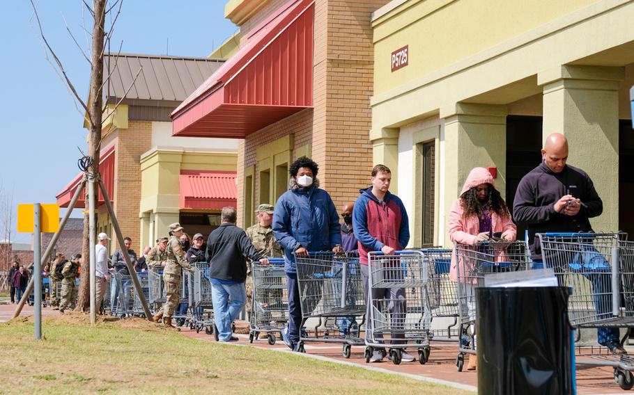 Customers wait in line to enter the commissary at Camp Humphreys, South Korea, Friday, March 27, 2020.