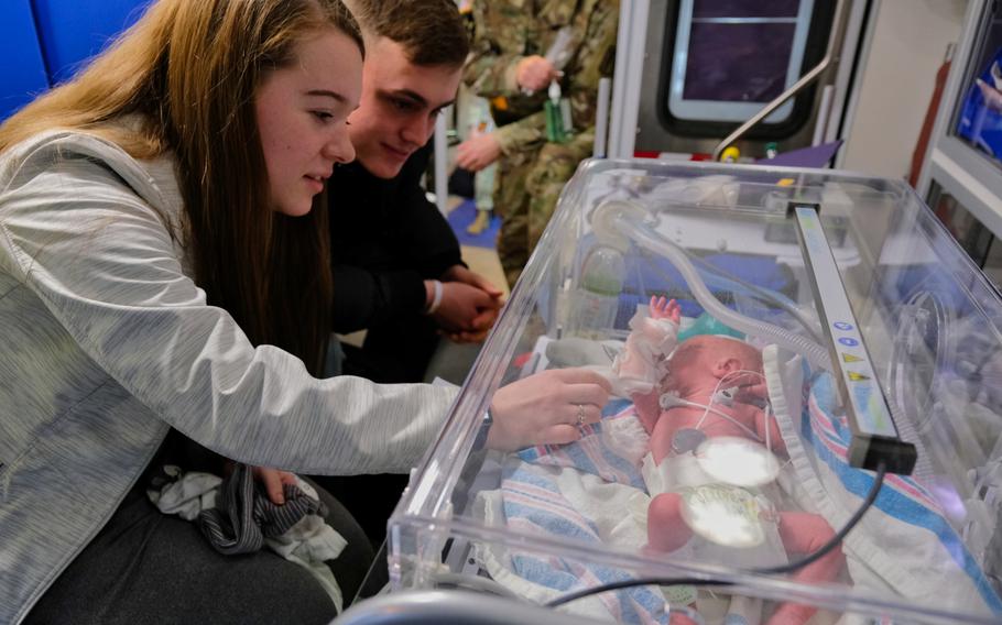 Pfc. Cheyenne Evans and her husband, Spc. Cody McFall, sit next to one of their newborn twins inside an ambulance at Osan Air Base, South Korea, Monday, March 30, 2020.