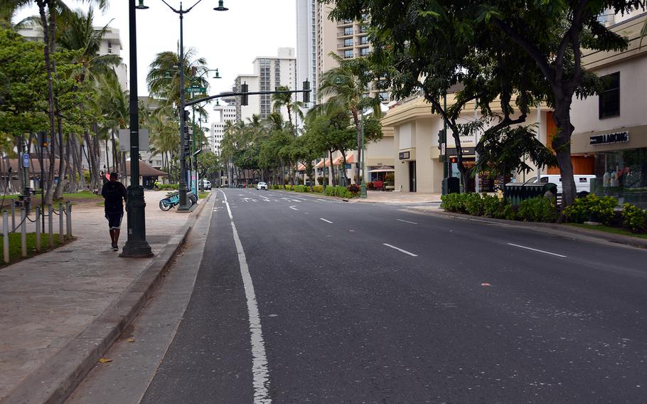 A Honolulu Police Department squad car keeps vigil over a barren Kalakaua Avenue, Waikiki Beach's main thoroughfare,  March 31, 2020.