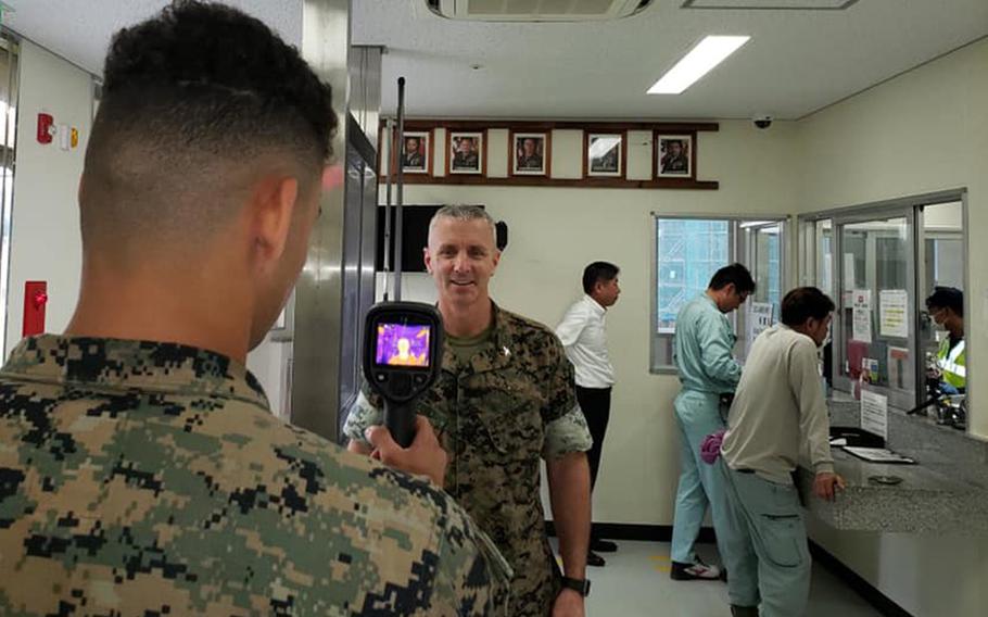 Col. Vincent Ciuccoli, commander of Headquarters and Support Battalion at Camp Smedley D. Butler, is screened for coronavirus symptoms at Camp Schwab, Okinawa, March 30, 2020.