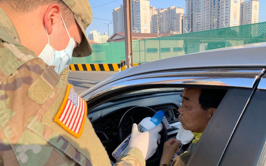 A driver takes a smell test as part of coronavirus screening measures at Camp Henry, South Korea, Friday, April 3, 2020.