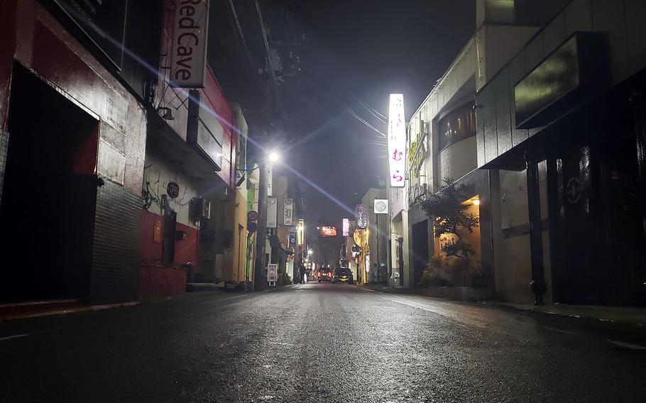 The street is nearly empty and many establishments are shuttered on Bar Row near Yokota Air Base, Japan, March 31, 2020.
