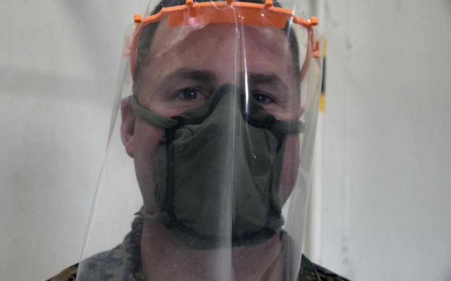 Chief Warrant Officer 4 Sean Flores of the III Marine Expeditionary shows off face mask and face shield frames that were 3D printed at Camp Kinser, Okinawa, Wednesday, April 8, 2020.