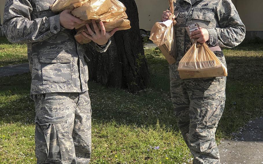 Air Force Capt. Lance Brown, a chaplain, and Airman 1st Class Stefanie Davidson, a chaplain's assistant, deliver worship materials to families coping with the coronavirus pandemic at Yokota Air Base, Japan.