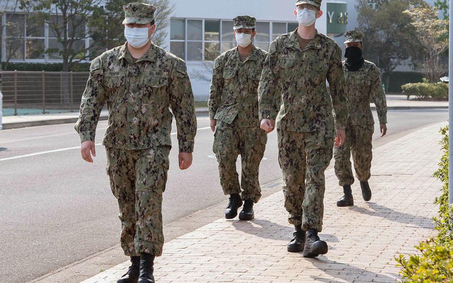 Sailors assigned to Sasebo Naval Base, Japan, wear face masks and practice social distancing while walking on base April 9, 2020.