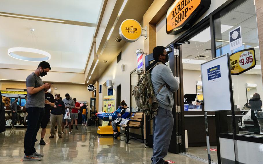 Customers practice social distancing while waiting to enter a barbershop at Camp Humphreys, South Korea, Saturday, April 18, 2020.