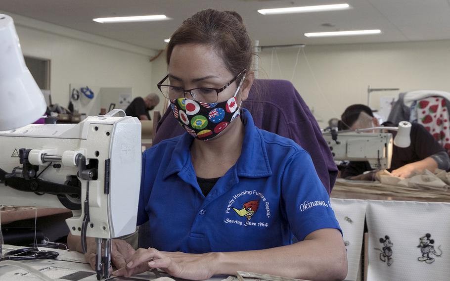 Nami Takaki, of the 718th Civil Engineer Squadron furniture repair shop, makes face masks out of dust-cover fabric at a warehouse outside Camp Shields, Okinawa, Monday, April 20, 2020.