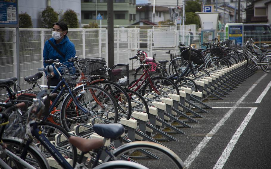 A man parks his bicycle near the main train station in Fussa, Japan, Thursday, April 23, 2020. Fussa borders Yokota Air Base, home of U.S. Forces Japan, 5th Air Force and the 374th Airlift Wing.