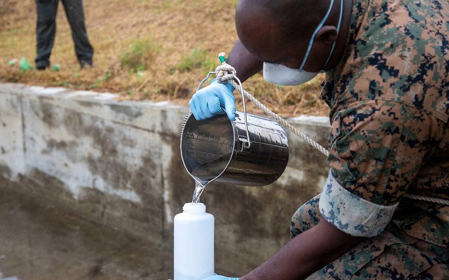 Marine Staff Sgt. Jovan Alexander prepares water samples for Japanese officials at Marine Corps Air Station Futenma, Okinawa, Tuesday, April 21, 2020.