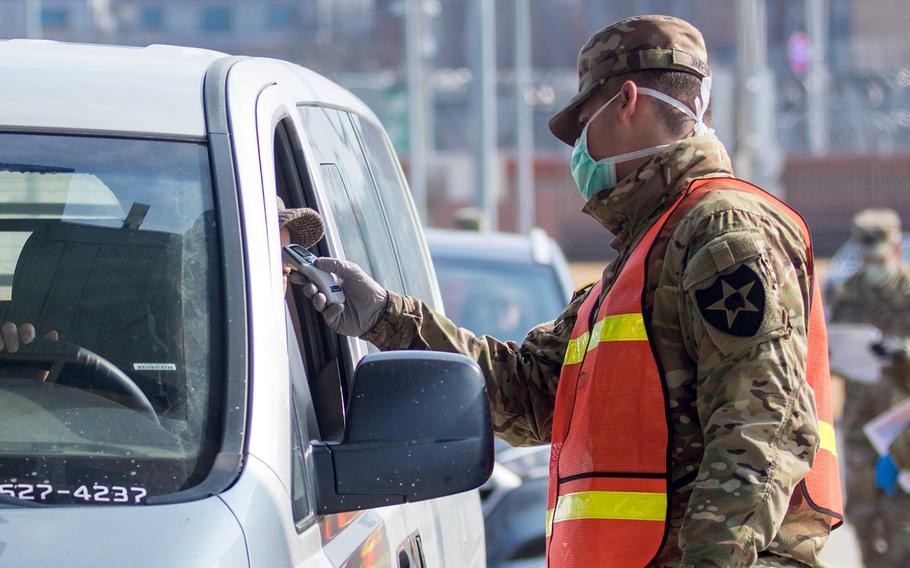 A motorist is screened for the coronavirus before entering Camp Humphreys, South Korea, Feb. 27, 2020.