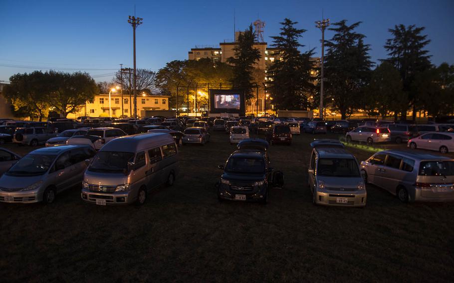 Families gather to watch a free drive-in movie on a sports field at Yokota Air Base, Japan, Saturday, April 25, 2020.