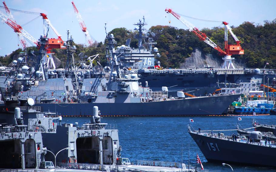 The aircraft carrier USS Ronald Reagan stands above other Navy and Japan Maritime Self-Defense Force ships at Yokosuka Naval Base, Japan, April 14, 2020.