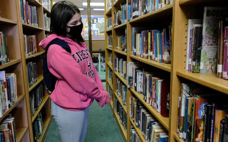 Osan Middle High School seventh-grader Charis Henry searches for a book at the Osan Air Base library in South Korea, Wednesday, April 29, 2020.