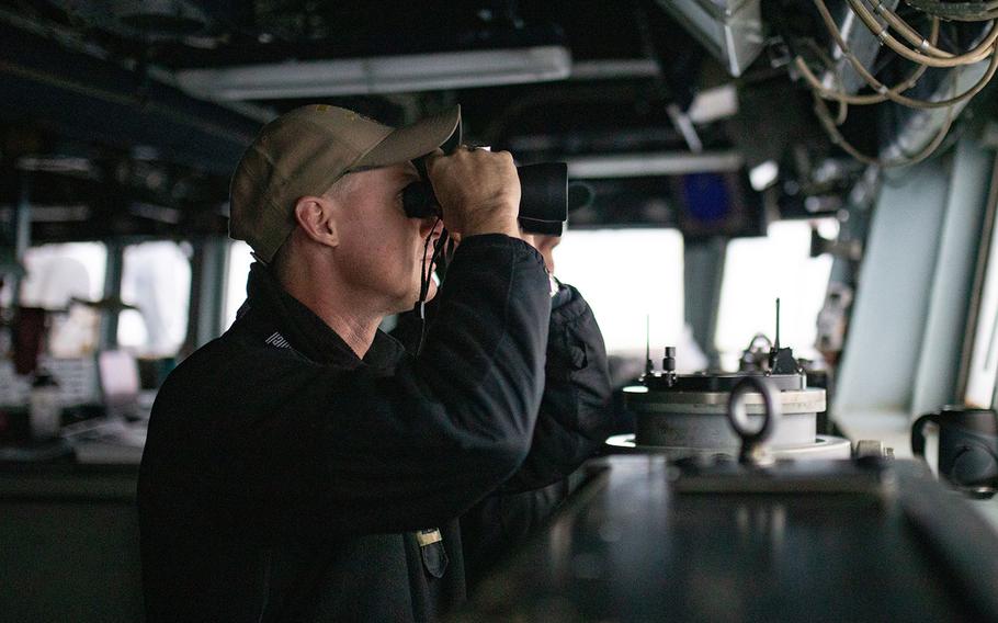 Lt. Richard Burk Vidmar stands watch on the bridge of the guided-missile destroyer USS Barry near the Paracel Islands in the South China Sea, Tuesday, April 28, 2020.