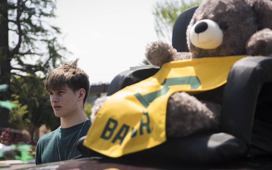 Yokota High School senior Austin Fisher helps his girlfriend, Allie Hill, decorate her car for a decision day parade at Yokota Air Base, Japan, Friday, May 1, 2020. Hill will attend Baylor University in Waco Texas, in the fall, while Fisher is enrolled at nearby Texas State Technical College.