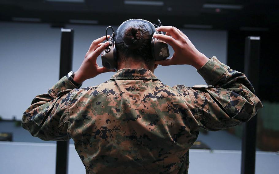 Cpl. Nitselly Henriquez Belliard, an administrative specialist with Marine Rotational Force — Darwin, puts on ear protection before shooting on the Weapon Training Simulation System at Robertson Barracks in Darwin, Northern Territory, Australia, April 29, 2020.