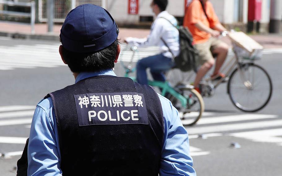 A policeman keeps an eye on a roadway in Yokohama, Japan, Monday, May 11, 2020.