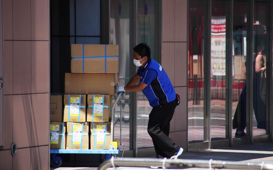 A worker delivers packages to businesses in Yokohama, Japan, Monday, May 11, 2020.