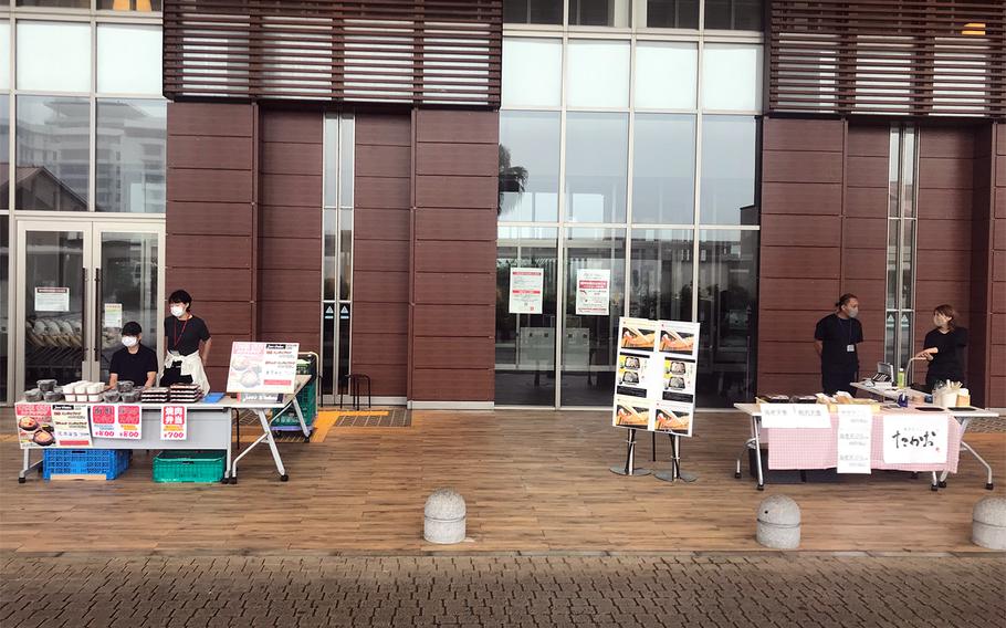 Restaurant workers sell to-go lunch boxes outside Aeon Mall Okinawa Rycom in Kitanakagusuku, Okinawa, Tuesday, May 12, 2020. The mall is closed because of the coronavirus pandemic.