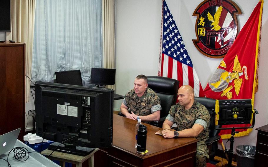 Lt. Col. Jason Kaufman, left, and Sgt. Maj. Carlos Lopez of Headquarters and Headquarters Squadron at Marine Corps Air Station Iwakuni, Japan, speak to Marines over Facebook Live on March 31, 2020.