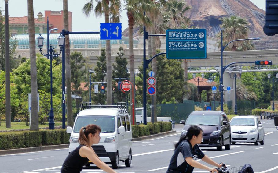 Cyclists ride near the Tokyo DisneySea theme park in Urayasu, Japan, Tuesday, May 12, 2020.
