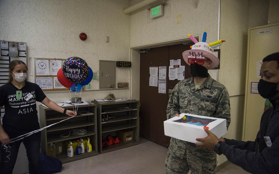 USO staff and volunteers surprise Airman 1st Class David Engle with a birthday cake and balloons at Yokota Air Base, Japan, Wednesday, May 13, 2020. Operation Birthday Cake allows a stateside family member to contact the USO to deliver a cake to a service member, even during the coronavirus pandemic.