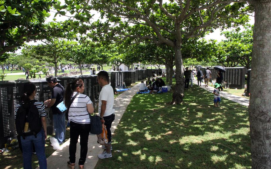 People visit the Cornerstone of Peace memorial during the Irei no Hi ceremony at Peace Memorial Park in Okinawa, Japan, June 23, 2018. The memorial lists the names of those who died in the Battle of Okinawa during World War II.