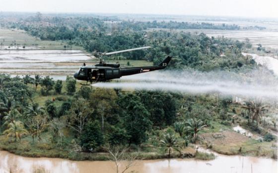 A U.S. Army Huey helicopter sprays Agent Orange herbicide and defoliant in this undated photo from the Vietnam War.