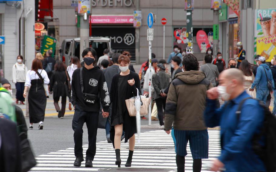 Masked pedestrians make their way across the Shibuya Scramble in central Tokyo, Friday, May 22, 2020.