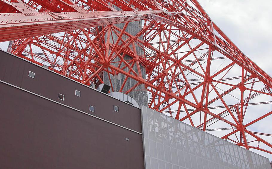 People sit at the base of Tokyo Tower on Thursday, May 28, 2020, the day it reopened after a state of emergency was lifted in the city because of the coronavirus pandemic.